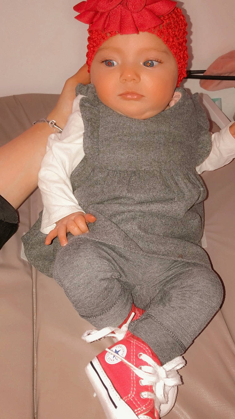 Ruby a rejoint le concours — aidez-le/la à gagner de superbes lots ! baby, baby_toddler_clothing, cheek, cool, finger, gesture, headwear, joint, lip, neck, outerwear, person, pink, red, skin, sleeve, standing, textile, thigh, thumb