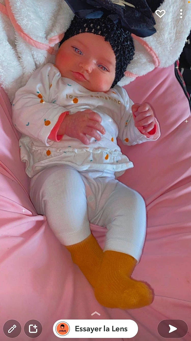 Ruby a rejoint le concours — aidez-le/la à gagner de superbes lots ! abdomen, baby, baby_toddler_clothing, comfort, doll, foot, headwear, human_leg, knee, lap, linens, magenta, person, pink, shorts, skin, sock, textile, thigh, toddler