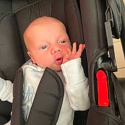 Kayden participe au concours pour gagner de l'argent avec cette photo : baby, infant, car_seat, black, white_clothing, blue_eyes, hand, face, seatbelt, straps, indoor, cute, child, young, newborn, expression, person, clothing, sitting, resting