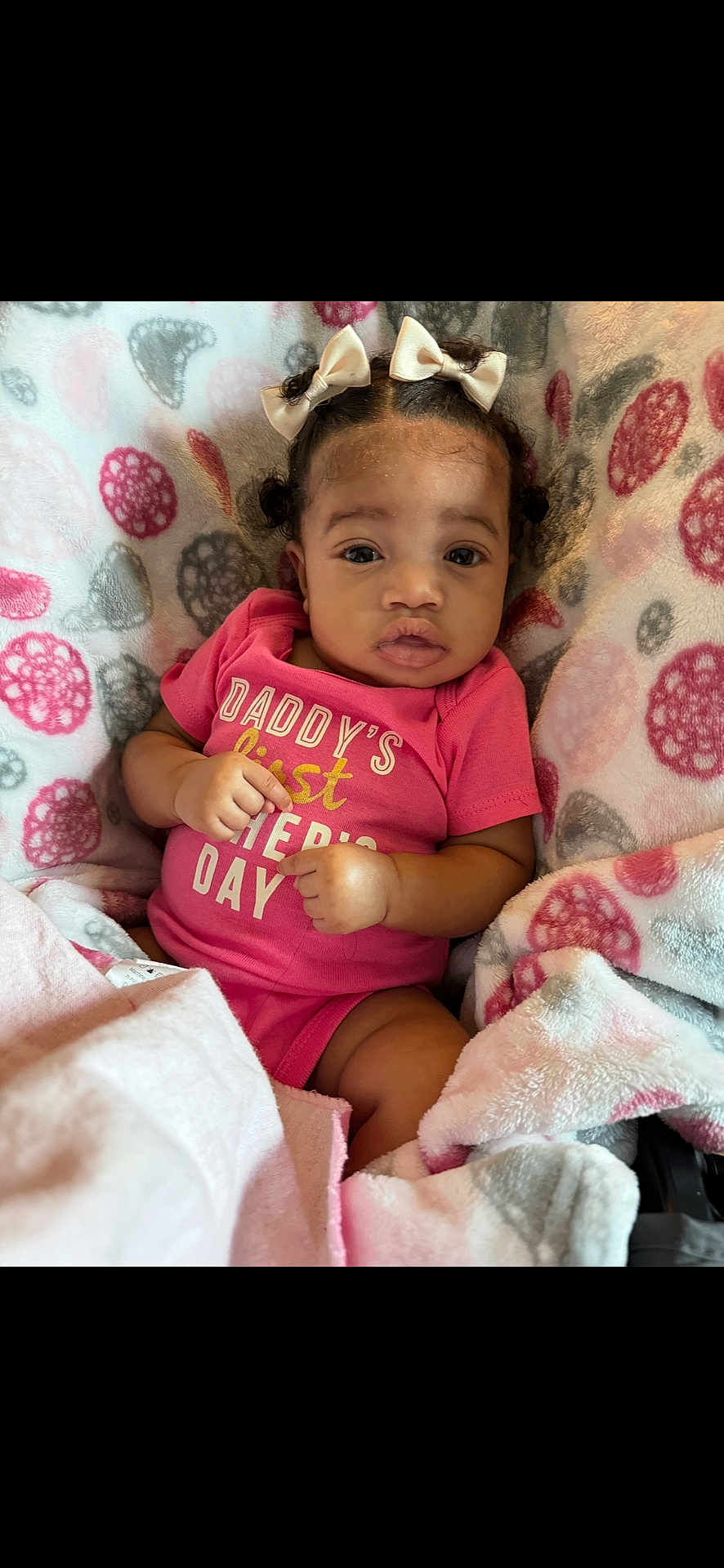 Aulani joined the competition — help win amazing prizes! baby, infant, child, girl, bows, pink_onesie, blanket, patterned_blanket, soft_texture, curious_expression, lying_down, indoors, cute, portrait, small_hands, head, face, eyes, mouth, cozy