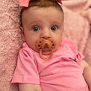 Payton joined the competition — help win amazing prizes! baby, pacifier, pink_bow, pink_shirt, blanket, infant, child, cute, portrait, face, wide_eyes, soft_texture, lying_down, indoors, closeup, skin, headwear, expression, comfort, adorable