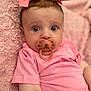 baby, pacifier, pink_bow, pink_shirt, blanket, infant, child, cute, portrait, face, wide_eyes, soft_texture, lying_down, indoors, closeup, skin, headwear, expression, comfort, adorable