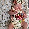 Zoe joined the competition — help win amazing prizes! baby, blanket, child, closeup, colorful, cute, floral_outfit, foot, hand, headband, indoors, infant, lying_down, pattern, person, playful, skin, soft_texture, toy, young_child