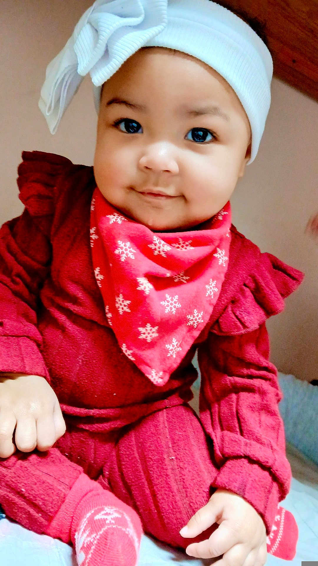 Airalyse is registered to the contest to win money with this photo: baby, infant, child, headband, bow, bandana, red_outfit, red_sweater, socks, smile, cheeks, big_eyes, portrait, indoor, sitting, hand, bed, blanket, cute, festive