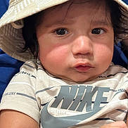 Gurpree is registered to the contest to win money with this photo: baby, child, face, hat, bucket_hat, clothing, nike, tshirt, arm, skin, cute, portrait, closeup, indoor, person, expression, young, infant, curious, wearing