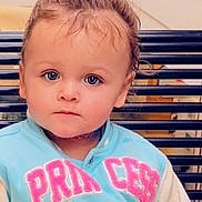 Sienna joined the competition — help win amazing prizes! toddler, child, face, blue_eyes, light_blue_jacket, princess_text, hair_tied, bench, portrait, serious_expression, indoor, young_child, cute, person, clothing, baby, head, sitting, closeup, casual