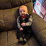 baby, child, tuxedo, bow_tie, armchair, brown_furniture, holiday_presents, christmas, gift_wrap, socks, cute, portrait, indoor, smile, infant, seated, cozy, festive, holiday_decor, young_child