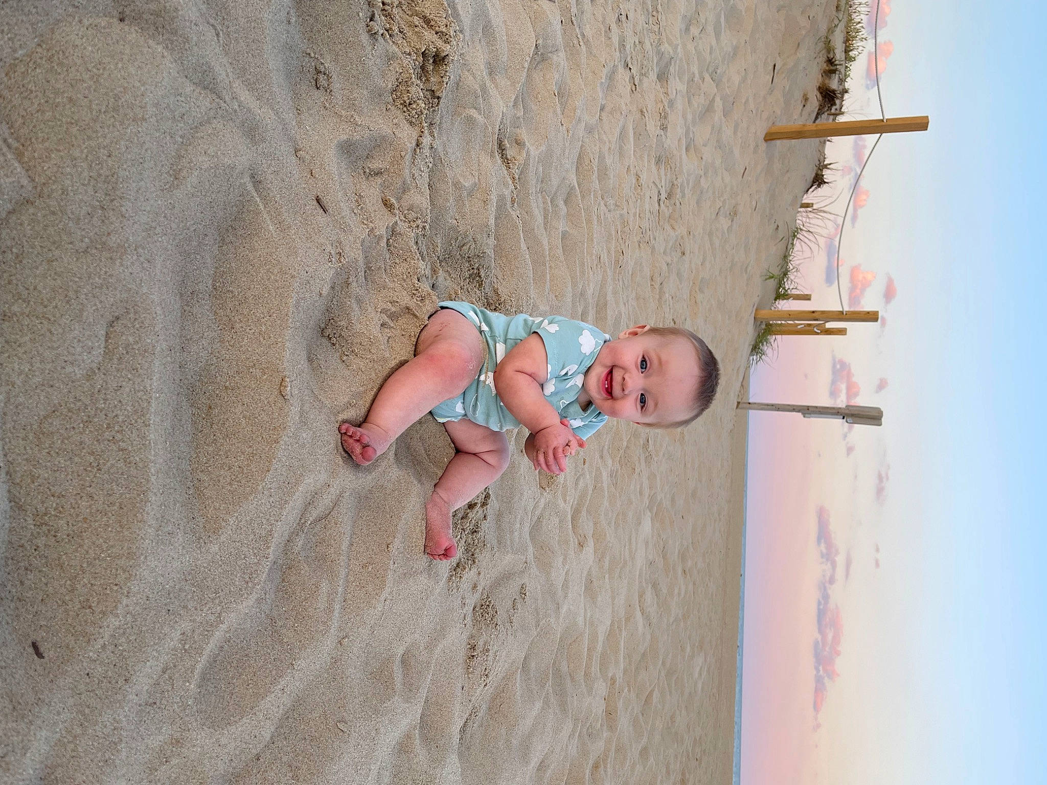 Austyn is registered to the contest to win money with this photo: baby, beach, body_of_water, child, concrete, eye, flooring, fun, happy, joy, landscape, leisure, person, recreation, sand, shadow, skin, sky, smile, toddler