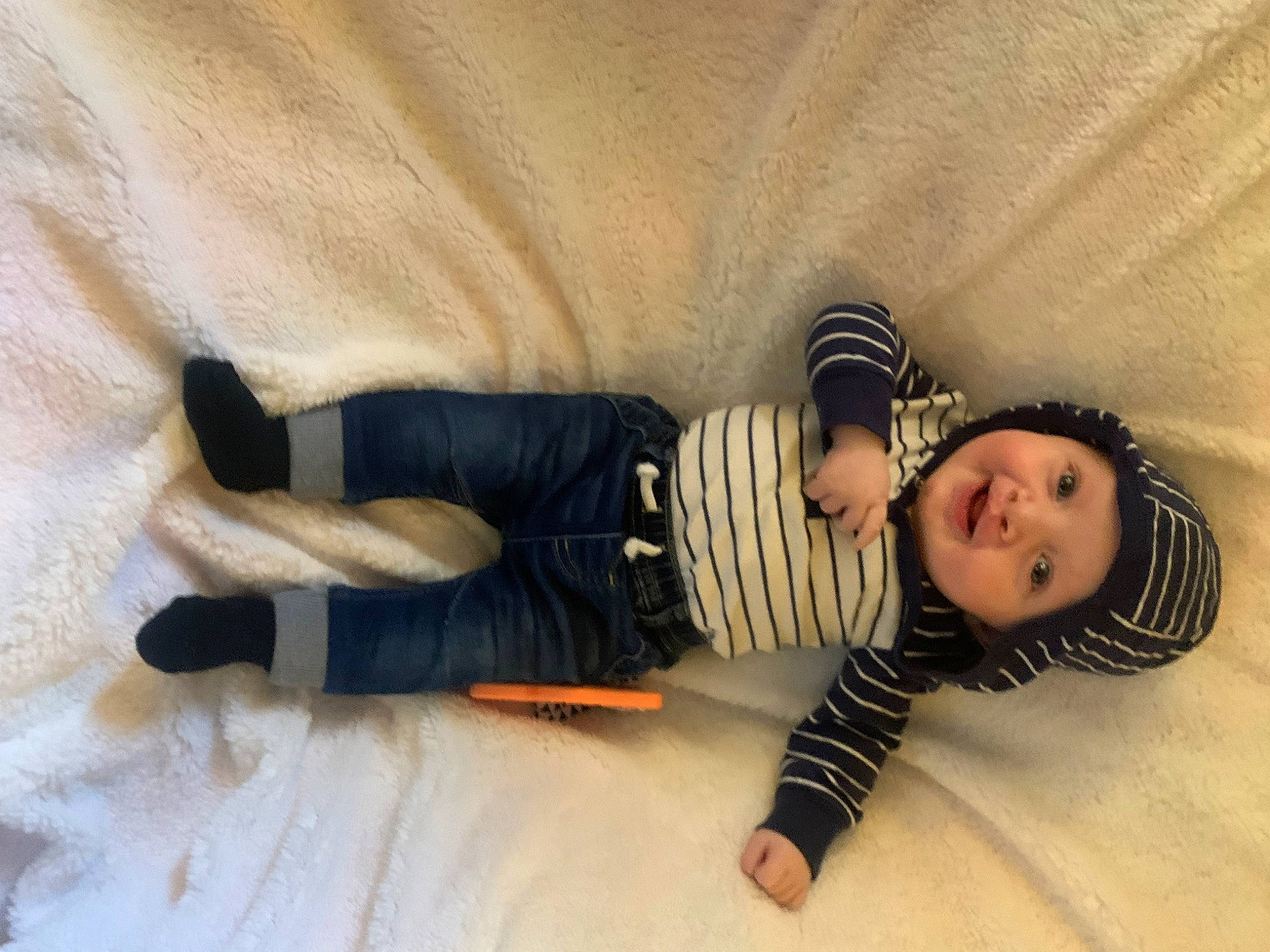 Noah is registered to the contest to win money with this photo: baby, baby_toddler_clothing, child, comfort, flooring, foot, fun, hardwood, headwear, human_leg, knee, linens, pattern, person, room, sitting, skin, sleeve, tints_and_shades, toddler