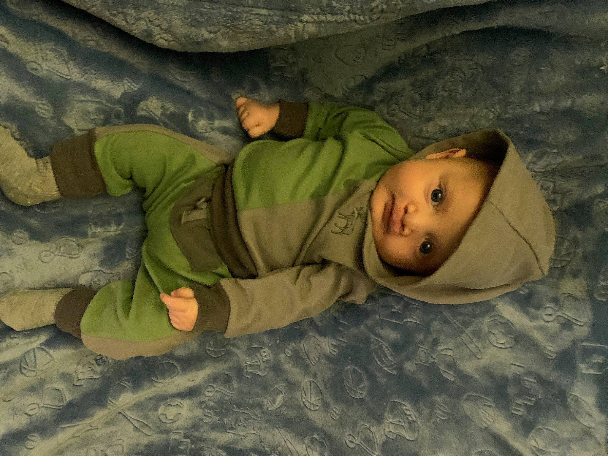 Noah is registered to the contest to win money with this photo: baby, camouflage, child, comfort, crawling, flooring, fun, fur, grass, headwear, jacket, landscape, linens, military, military_camouflage, military_person, person, personal_protective_equipment, room, sleep