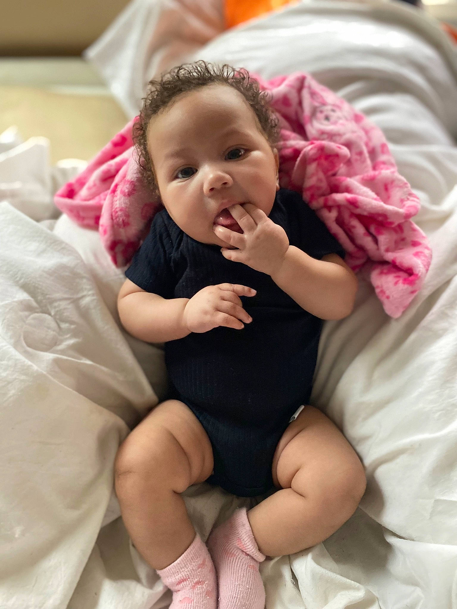Jaylani joined the competition — help win amazing prizes! baby, baby_toddler_clothing, cheek, child, comfort, dress, event, face, facial_expression, finger, gesture, happy, human_leg, lip, person, pink, sitting, skin, smile, thigh