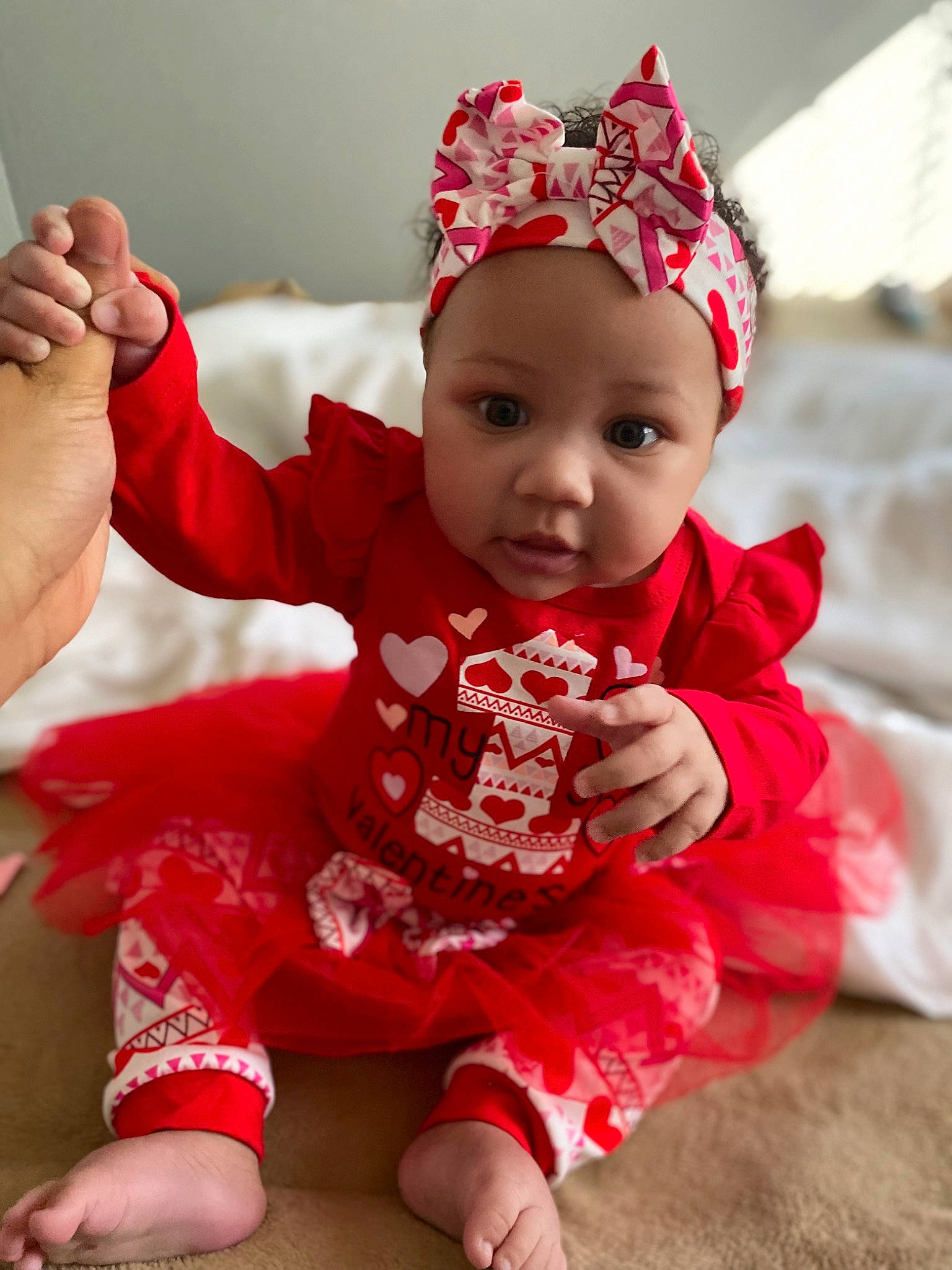 Jaylani joined the competition — help win amazing prizes! baby, baby_toddler_clothing, cap, child, face, foot, fun, gesture, happy, headband, headpiece, headwear, magenta, pattern, person, pink, red, skin, sleeve, smile