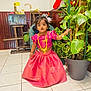 Alexia a rejoint le concours — aidez-le/la à gagner de superbes lots ! child, curious_expression, decor, face, floor, gold_jewelry, greenery, hair_accessory, indoor, indoor_plant, person, pink_dress, plant, pot_plant, room, standing, tile_floor, toddler, traditional_clothing, wooden_furniture