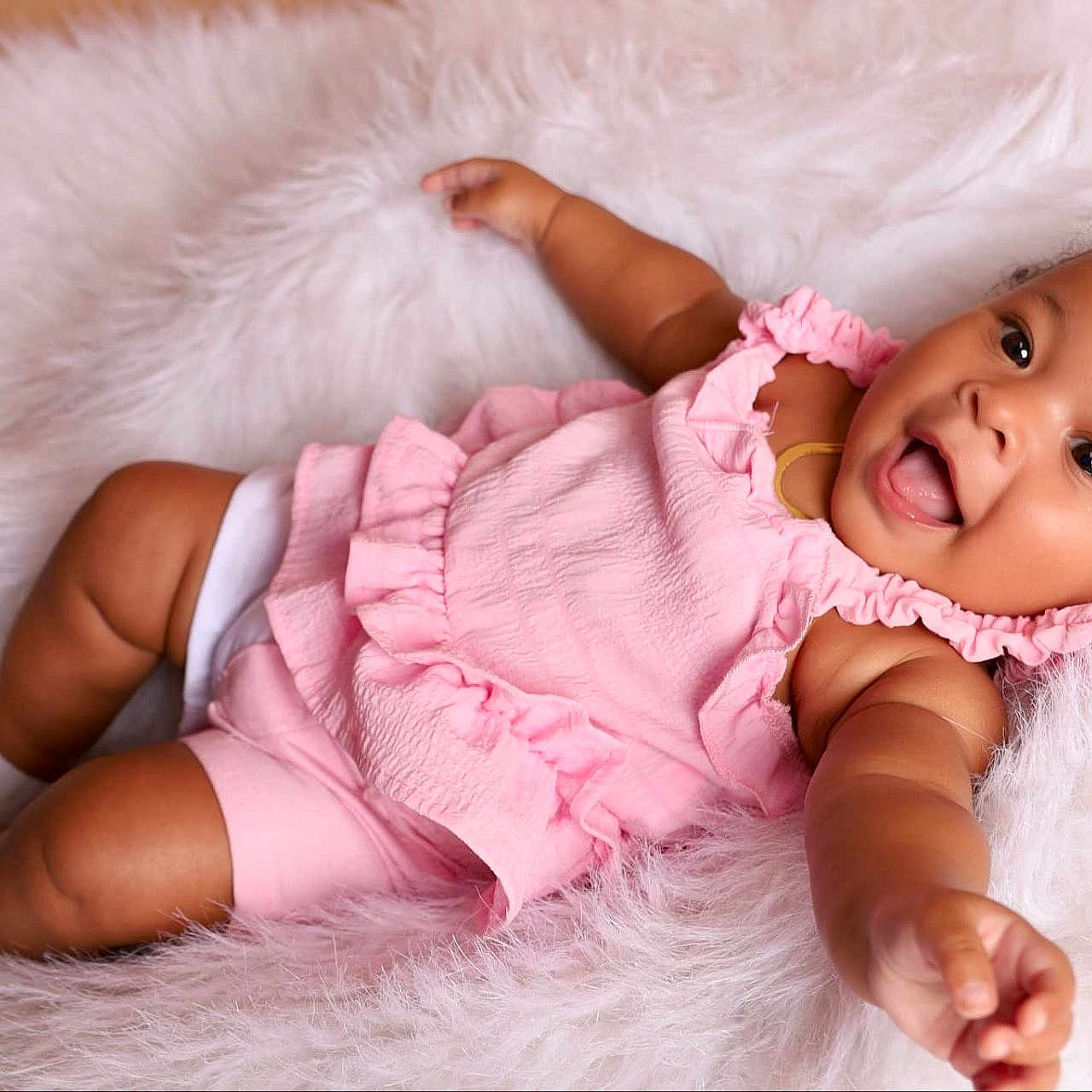 Ohana is registered to the contest to win money with this photo: baby, babylaughing, clothing, dress, face, happy, head, laughing, newborn, person, photography, portrait, sitting, smile