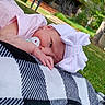 baby, newborn, pacifier, pink_clothing, bow_hat, blanket, black_and_white, checkered, outdoor, grass, tree, nature, infant, relaxing, headwear, portrait, child, peaceful, lying_down, summer