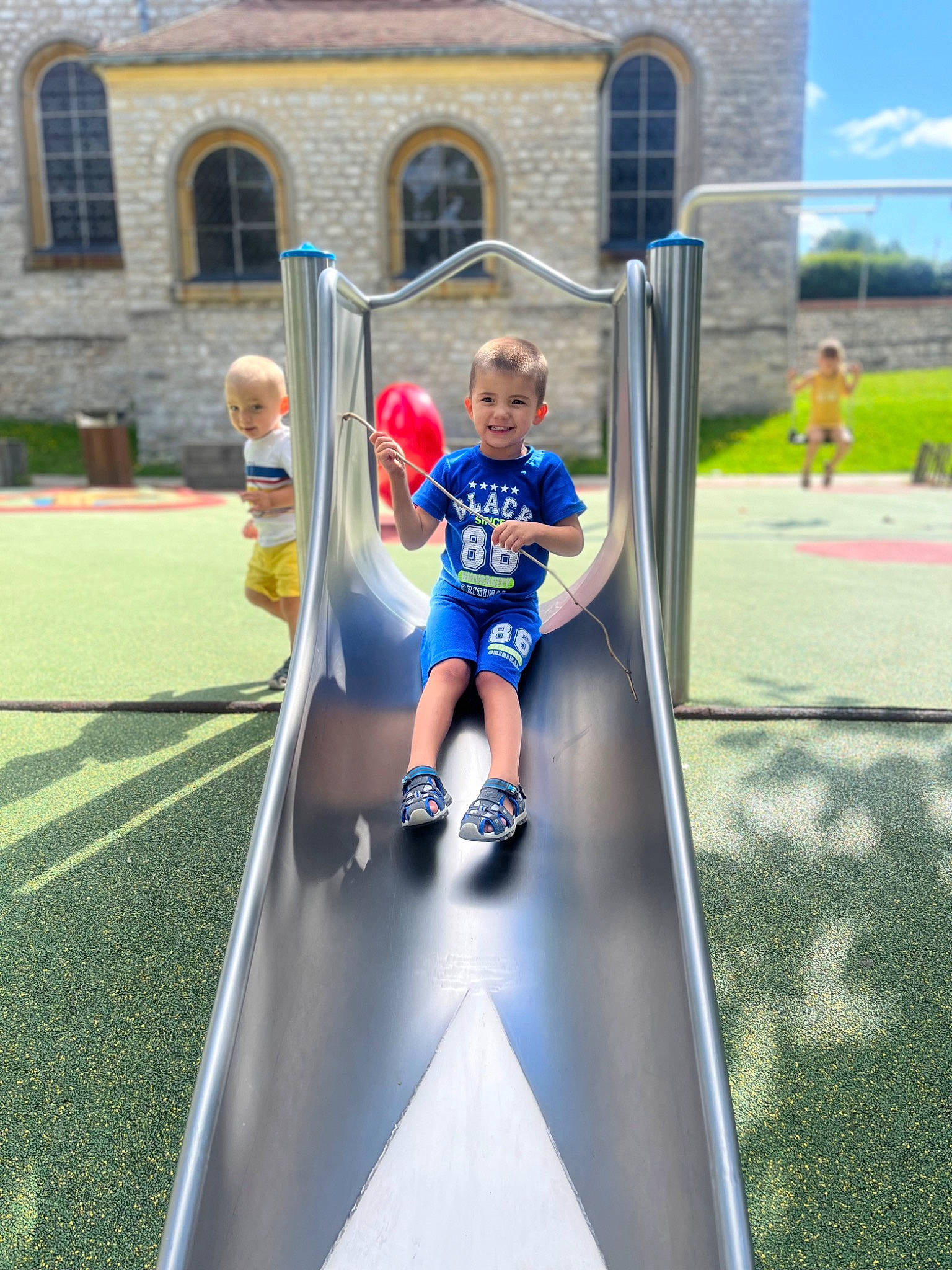 Timothé participe au concours pour gagner de l'argent avec cette photo : baby_toddler_clothing, child, chute, city, fun, grass, human_settlement, joy, leisure, outdoor_play_equipment, person, play, player, playground, playground_slide, recreation, shorts, sports, sportswear, t_shirt