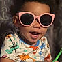 casual, child, colorful_clothing, cute, dinosaur_shirt, face, funny, hand, happy, holding_object, indoor, person, pink_sunglasses, playful, portrait, short_hair, smiling, sunglasses, toddler, young_child
