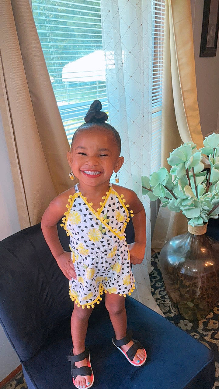 Alaiyah is registered to the contest to win money with this photo: child, door, dress, eyewear, flooring, fun, happy, hat, human_leg, joy, leisure, magenta, pattern, person, room, sandal, smile, standing, t_shirt, toddler