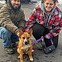 Quincy is registered to the contest to win money with this photo: man, woman, dog, leash, asphalt, snow, car, jacket, hoodie, boots, purple_leash, crouching, smiling, outdoor, pet, animal, winter, parking_lot, casual_clothing, daylight