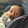 baby, blanket, candid, car_interior, car_seat, child, clothing, comfort, face, indoors, infant, pacifier, portrait, safety, seat, seatbelt, soft_light, transportation, window, young_child