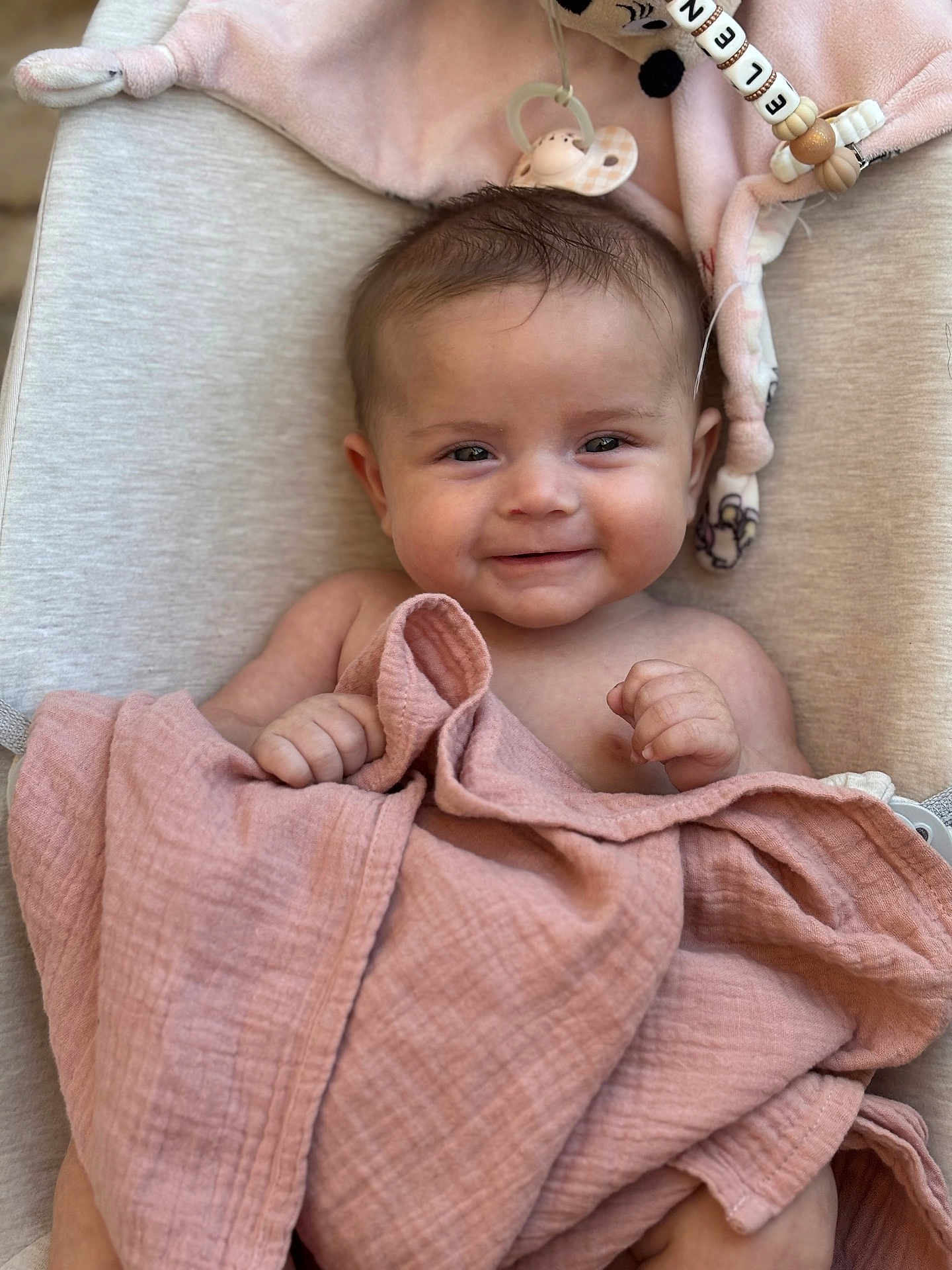 Elena participe au concours pour gagner de l'argent avec cette photo : baby, blanket, smile, infant, soft_toy, pacifier, cushion, fabric, skin, hand, face, cute, young_child, comfort, indoors, closeup, expression, relaxation, child, portrait