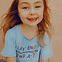 child, smiling, happy, tshirt, long_hair, blond, face, portrait, outdoor, casual_clothing, young, person, sitting, light_skin, wall, texture, colorful, bright, daylight, cute