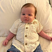 Grayson is registered to the contest to win money with this photo: baby, infant, smiling, shirt, shorts, pillow, white, cute, child, portrait, skin, hair, button, sitting, indoors, soft, comfortable, young, face, relaxed