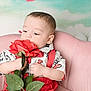 Wolftyn is registered to the contest to win money with this photo: toddler, child, rose, flower, pink_chair, red_suspender, white_shirt, heart_shape, curious, indoor, portrait, cute, smelling, plant, soft_furniture, baby, background, colorful, young_child, sitting