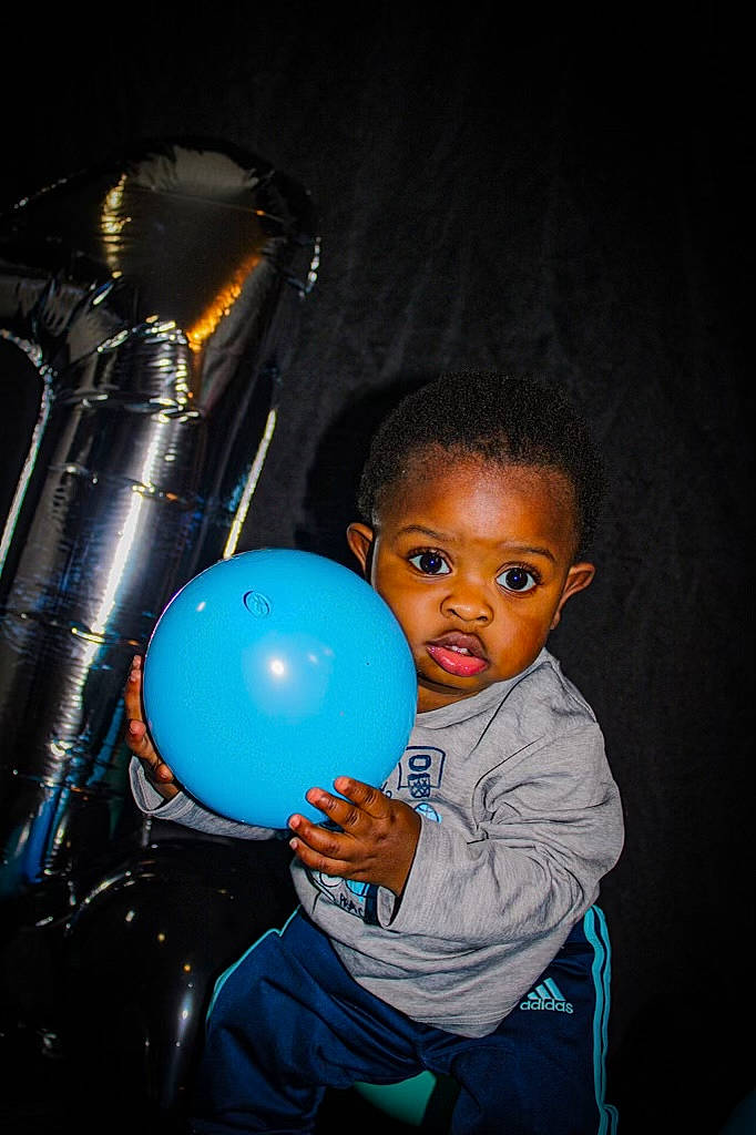 Jamylen Holloman is registered to the contest to win money with this photo: arm, baby, baby_toddler_clothing, ball, balloon, child, darkness, electric_blue, flash_photography, fun, happy, leisure, party_supply, person, personal_protective_equipment, play, recreation, sitting, sphere, t_shirt