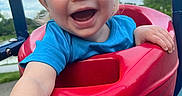 River joined the competition — help win amazing prizes! child, toddler, smiling, swing, playground, outdoor, blue_shirt, red_swing, happy, person, shorts, daylight, park, grass, trees, play, fun, cute, baby, summer
