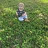 River joined the competition — help win amazing prizes! child, toddler, grass, outdoor, greenery, boots, shirt, curious, sitting, nature, sunlight, young_child, casual_clothing, daylight, small_person, lawn, playful, baby, portrait, cute