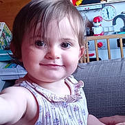 Camille participe au concours pour gagner de l'argent avec cette photo : toddler, child, smiling, indoor, couch, wooden_wall, toy_kitchen, television, curly_hair, sleeveless_top, person, face, furniture, playful, home, baby, cute, portrait, happy, living_room