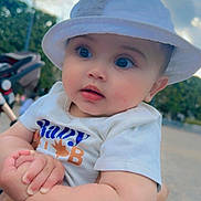Alseny-Arthur a rejoint le concours — aidez-le/la à gagner de superbes lots ! baby, child, hat, white_hat, tshirt, blue_jeans, outdoor, sky, clouds, hand, person, cute, portrait, holding, greenery, daylight, expression, infant, casual_clothing, closeup