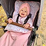 autumn, baby, baby_clothes, blanket, child, cute, daylight, fall_leaves, handlebar, happy, infant, nature, outdoor, person, pink_hat, portrait, seat, smiling, stroller, warm_clothing