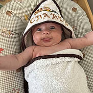 Charly participe au concours pour gagner de l'argent avec cette photo : baby, towel, hood, tongue_out, cushion, animal_print, infant, cute, child, smiling, playful, arms_outstretched, blanket, soft, indoors, happy, portrait, closeup, skin, expression