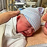newborn, baby, infant, parent, hospital, blanket, hat, skin, hand, closeup, face, sleeping, hospital_room, medical_equipment, love, family, care, tenderness, newborn_hat, wrapped