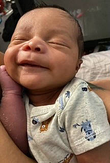 Davion is registered to the contest to win money with this photo: baby, baby_toddler_clothing, cheek, child, comfort, eyelash, gesture, happy, laugh, mouth, nose, person, skin, sleeve, smile, thumb, toddler, wrinkle