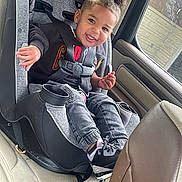 Karti joined the competition — help win amazing prizes! toddler, child, car_seat, car_interior, smiling, hair_bun, casual_clothing, sneakers, seatbelt, window, daylight, happy, person, young_child, car, seat, interior, safety, portrait, cute