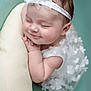 Eïlynn a rejoint le concours — aidez-le/la à gagner de superbes lots ! baby, smiling, sleeping, headband, white_dress, flower, soft_cushion, resting, cute, infant, portrait, peaceful, child, toddler, closeup, adorable, baby_girl, skin, hand, face