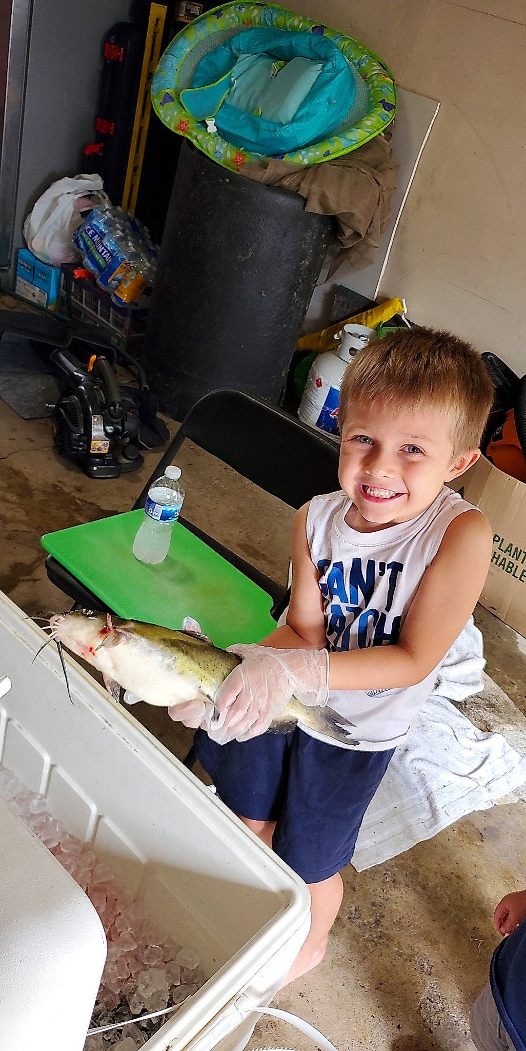 Ricky is registered to the contest to win money with this photo: box, chair, child, event, fun, happy, joy, leisure, person, plastic, play, recreation, room, shorts, sitting, smile, social_group, t_shirt, table, toddler