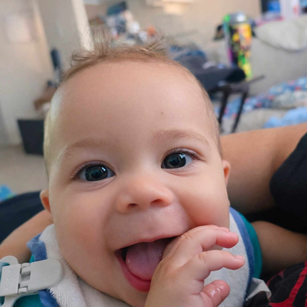 Kaleo joined the competition — help win amazing prizes! baby, infant, smiling, happy, face, hand, tongue, indoor, person, clothing, bib, closeup, cute, child, portrait, playful, skin, eyes, expression, fun