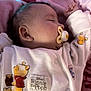 baby, sleeping, pacifier, blanket, winnie_the_pooh, onesie, infant, child, cute, soft_lighting, pink, cozy, resting, peaceful, indoors, clothing, portrait, face, head, newborn