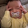 baby, infant, pacifier, sleeping, yellow_onesie, elephant_print, hands_on_head, soft_blanket, cozy, closeup, face, closed_eyes, cute, newborn, child, indoor, portrait, peaceful, resting, human