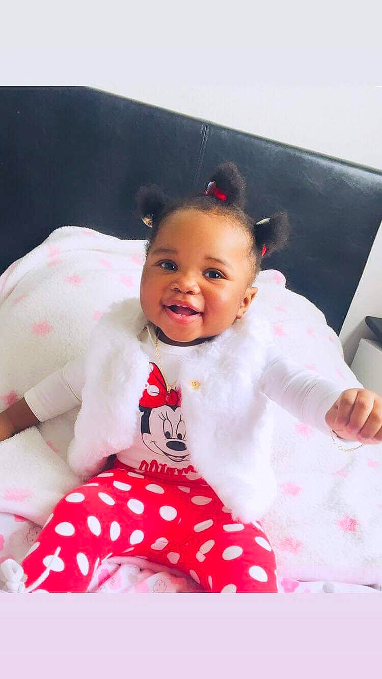 Hendrika a rejoint le concours — aidez-le/la à gagner de superbes lots ! baby, baby_toddler_clothing, child, comfort, face, fun, happy, head, joy, linens, magenta, pattern, person, pink, portrait_photography, room, sitting, skin, sleeve, smile