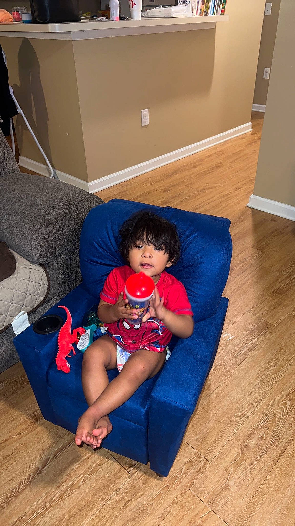 Francisco is registered to the contest to win money with this photo: baby_toddler_clothing, comfort, couch, floor, flooring, fun, hardwood, human_leg, knee, laminate_flooring, leisure, living_room, person, room, sitting, sock, studio_couch, thigh, toddler, wood