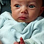 baby, infant, face, hand, thumb, clothing, white_outfit, person, portrait, cute, expression, skin, newborn, indoor, holding, parent, soft, young_child, looking, closeup