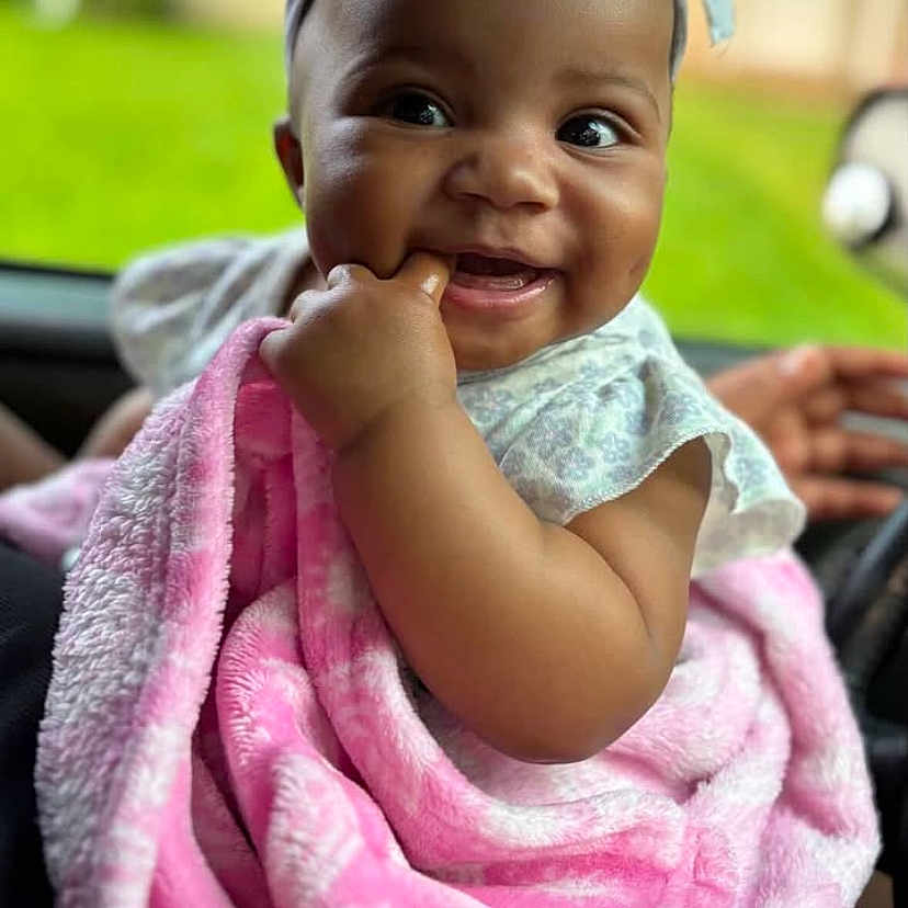 Kiaris joined the competition — help win amazing prizes! baby, blanket, bow, car, child, clothing, cute, dimple, face, fingers, hand, happy, headband, infant, outdoor, pink, portrait, seat, skin, smiling