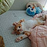 kitten, cat, bed, blanket, plush_toy, orange_and_white, stretching, cute, feline, indoor, cozy, paw, sleepy, soft, comfort, toy, resting, pet, animal, furry