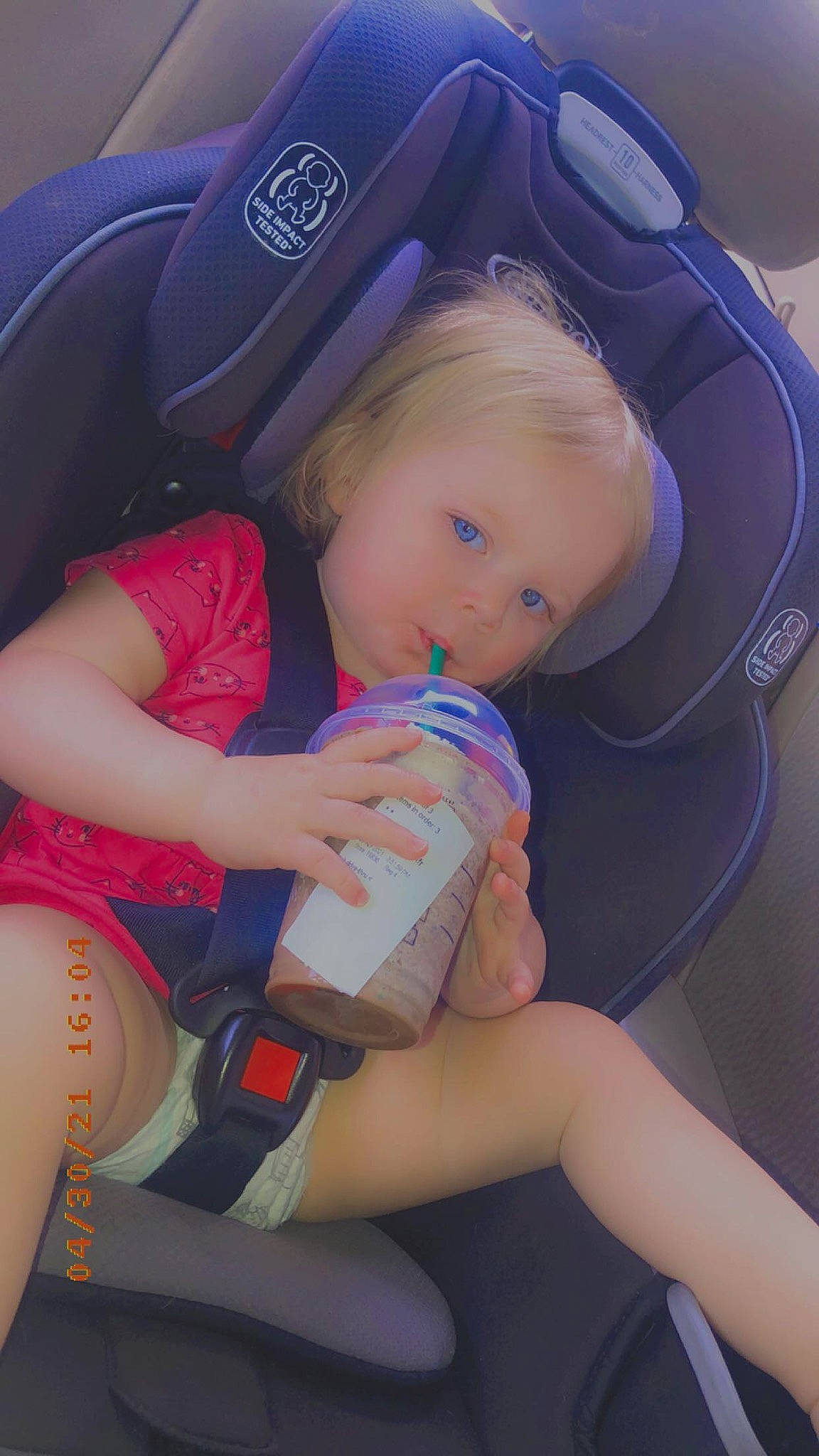 Renesmae is registered to the contest to win money with this photo: baby, baby_in_car_seat, blond, car_seat, comfort, electric_blue, finger, fun, human_body, human_leg, knee, lap, leg, mouth, nail, person, sitting, skin, thigh, thumb