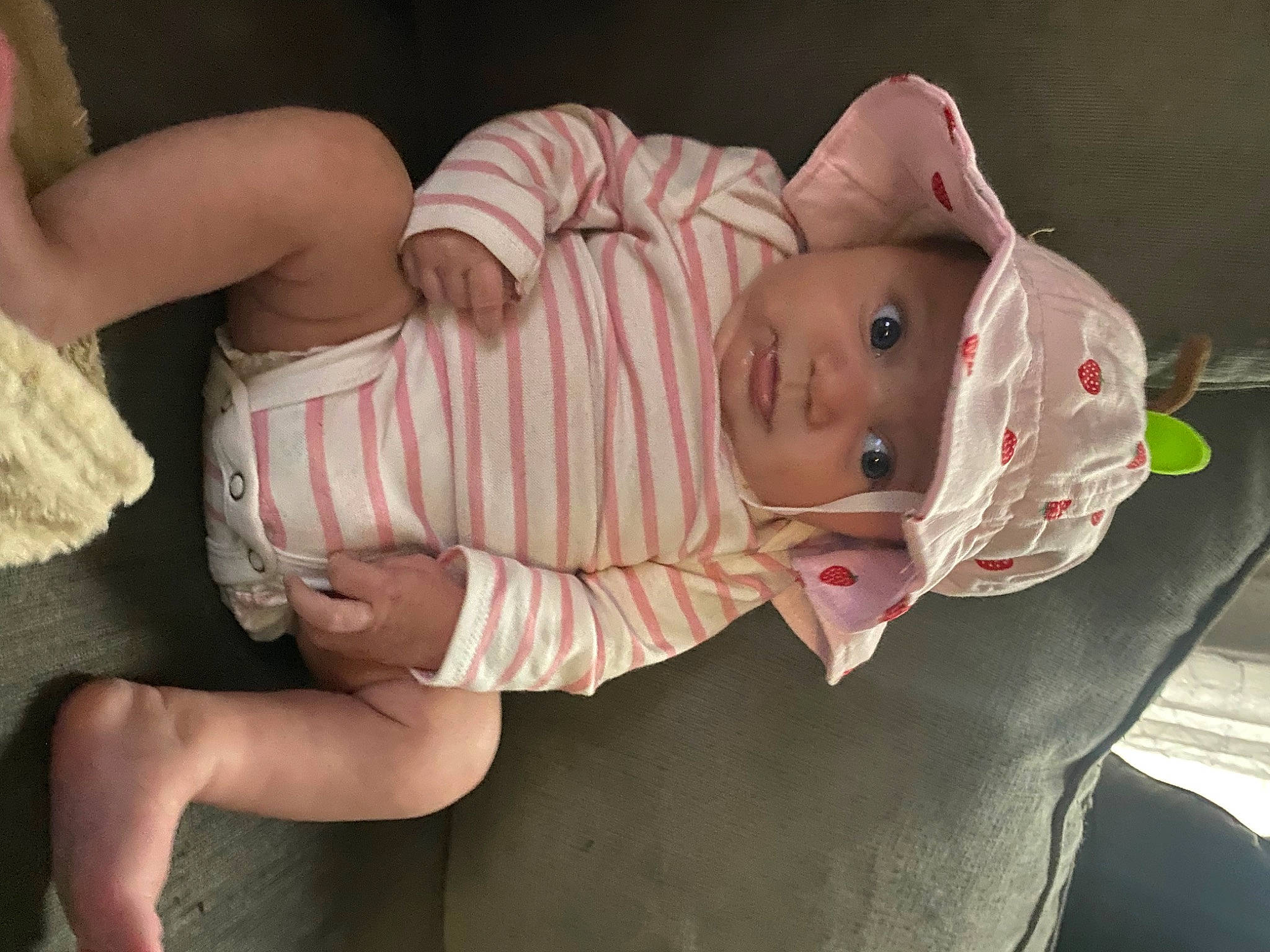 Lucille is registered to the contest to win money with this photo: baby, baby_toddler_clothing, cheek, child, comfort, elbow, eye, face, fun, gesture, head, headgear, headwear, human_body, mouth, nose, person, pink, sitting, skin